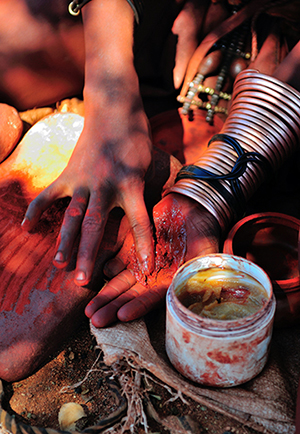 Himba,Woman,Mixing,Red,Ochre,With,Petroleum,Jelly,To,Apply